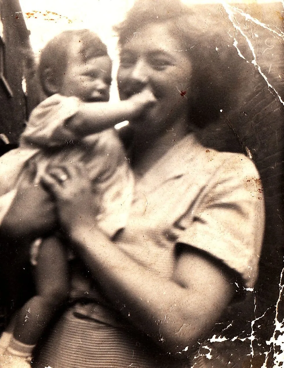 Old family photograph of Sandra, the 'Nanny' behind Nana Sans, smiling as she holds a baby